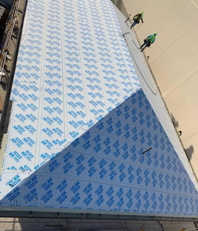 Professional roofers installing underlayment on a metal roof in Petersburg